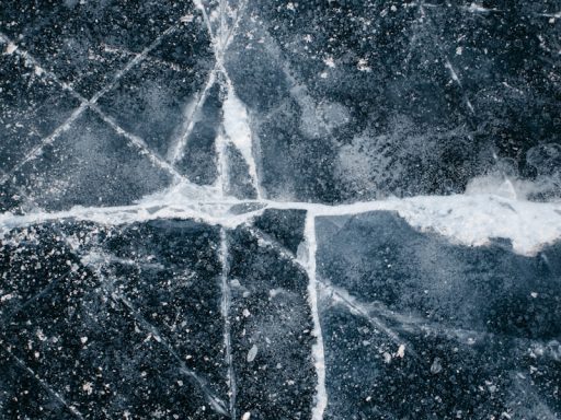 a black and white photo of a cross made of ice