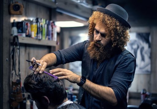Man in kappersstoel die een permanentje laat zetten