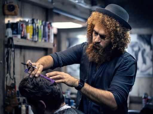 Man in kappersstoel die een permanentje laat zetten