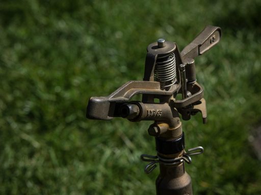 Automatisch beregeningssysteem met sproeiers op een groen gazon in een tuin