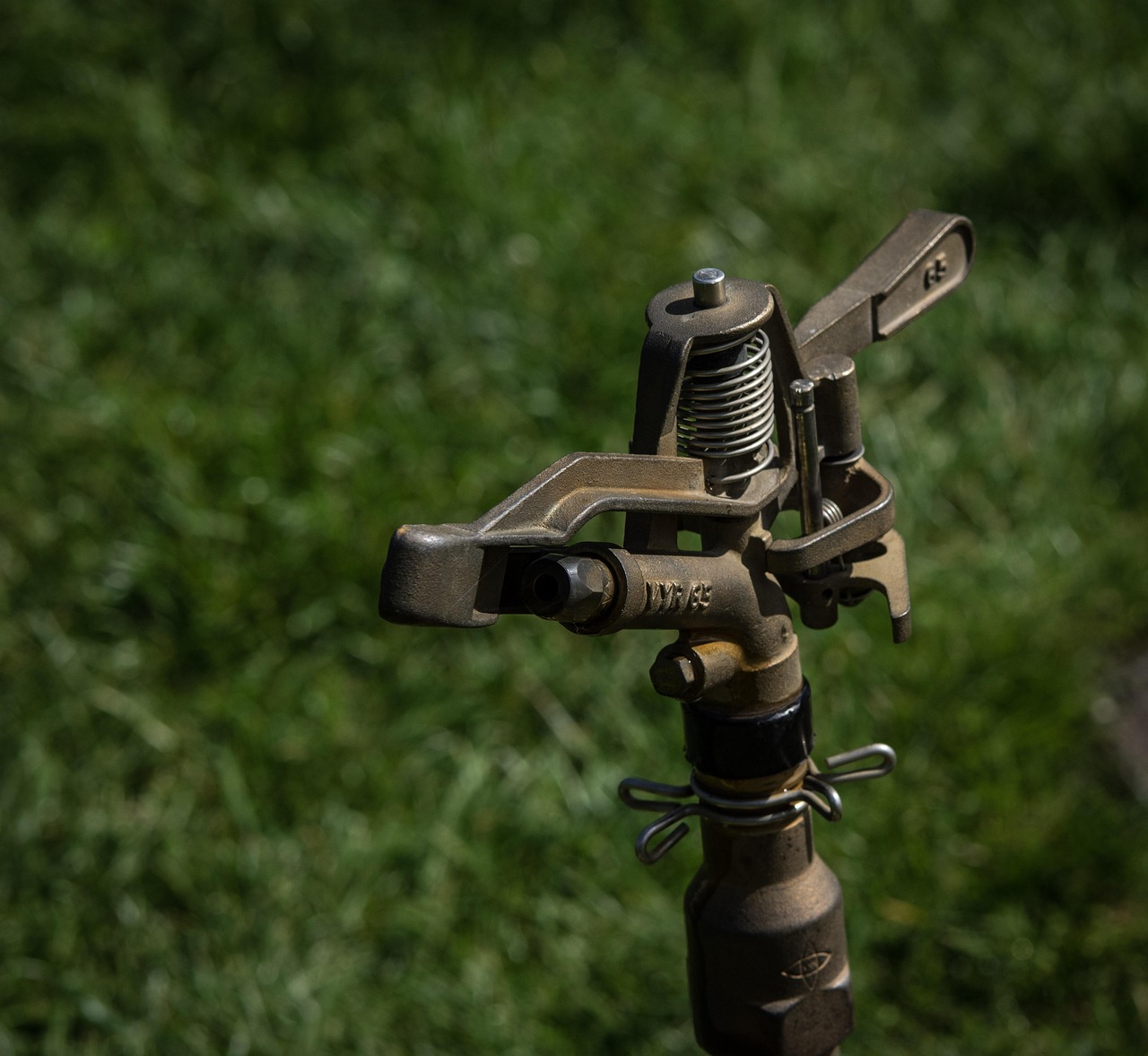 Automatisch beregeningssysteem met sproeiers op een groen gazon in een tuin