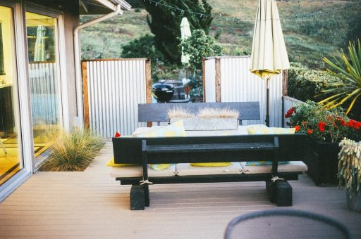 Hardhouten vlonder in een moderne achtertuin met loungeset en barbecue