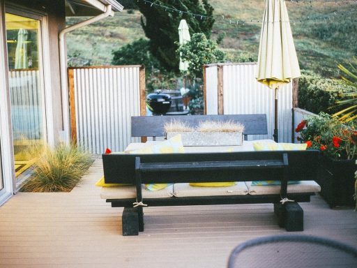 Hardhouten vlonder in een moderne achtertuin met loungeset en barbecue
